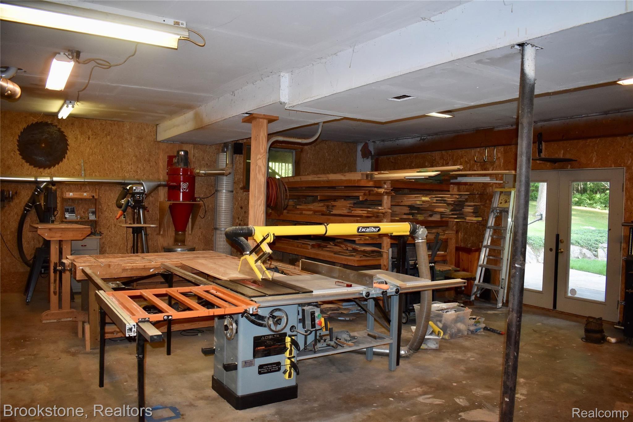 405 Baldwin Ridge Oxford, MI 48371 - Photo 12 of 54 THE OWNER HAS A WOODWORKING BACKGROUND & SAW OPPORTUNITY TO HARVEST TREES ON THE PROPERTY TO BUILD MUCH OF THE BUILT-IN CABINETRY & CUSTOM TRIM THAT YOU SEE IN THE HOUSE. THE LARGE HEATED WORKSHOP (28X36) HAS A 9 FT CEILING & A DOOR WALL THAT ALLOWS EASY ACCESS FOR THOSE LARGE PROJECTS