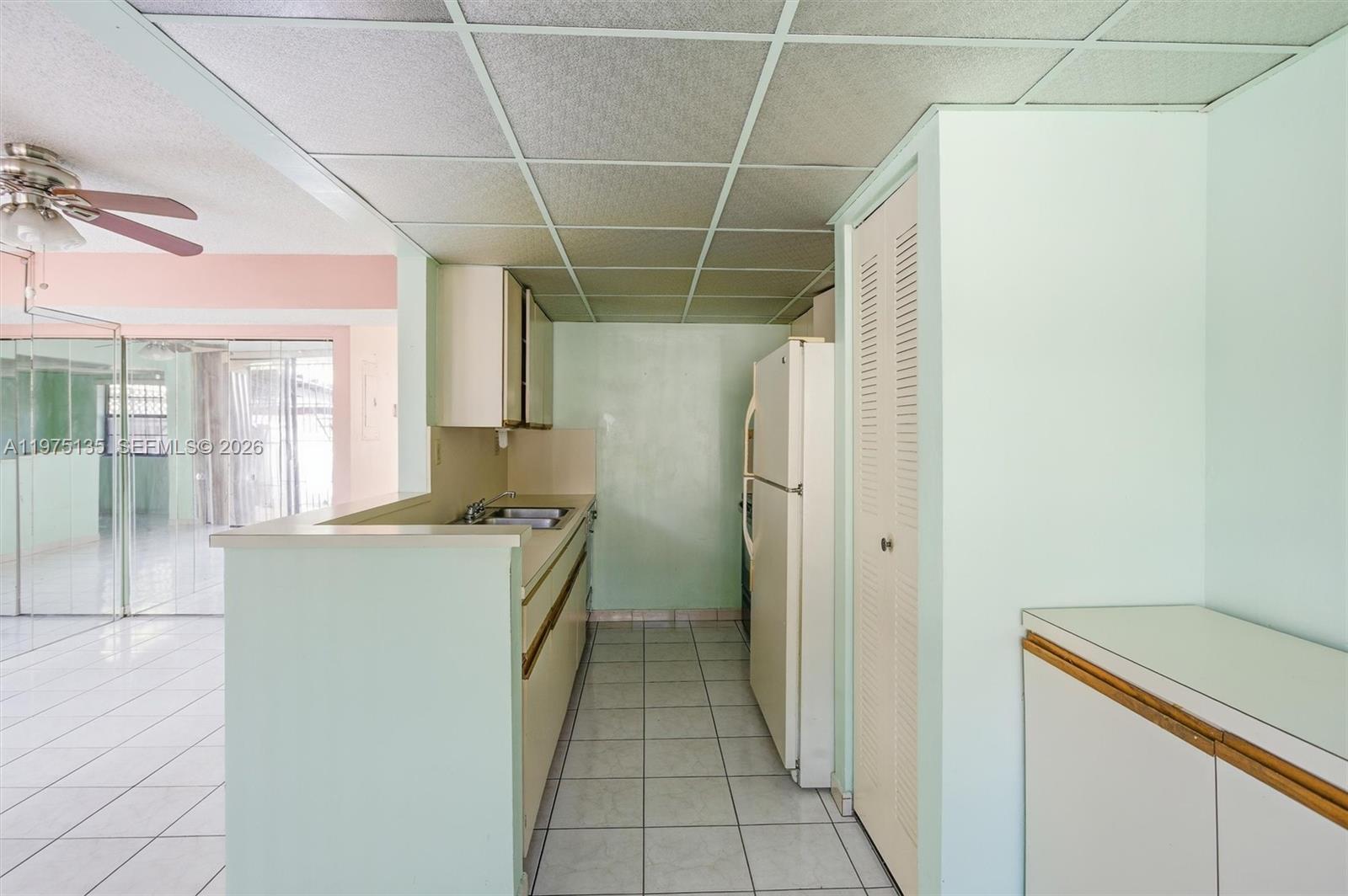 12253 Southwest 16th Terrace, Unit 108M Miami, FL 33175 - Photo 17 of 50 a kitchen with a refrigerator and a sink