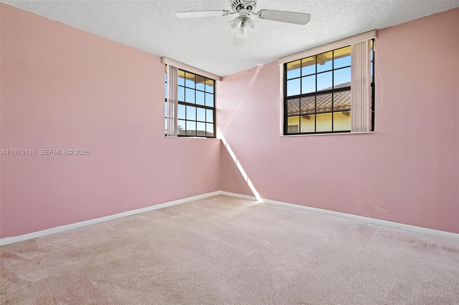 12253 Southwest 16th Terrace, Unit 108M Miami, FL 33175 - Photo 21 of 50 an empty room with windows and ceiling fan