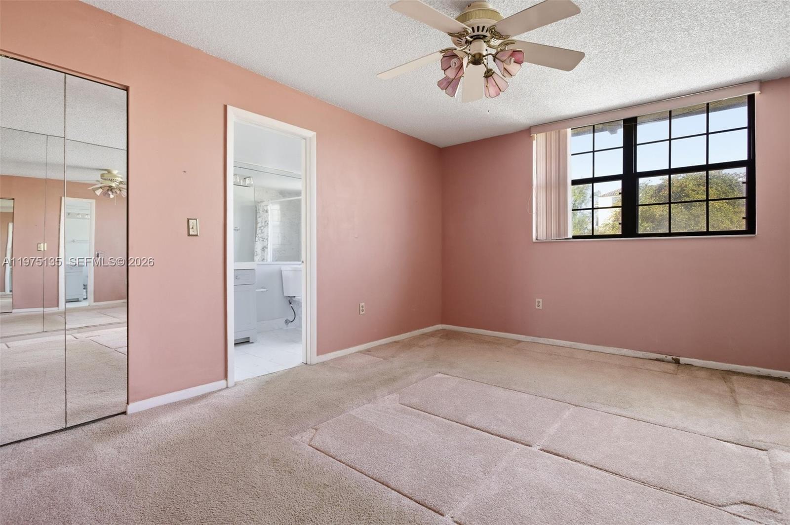 12253 Southwest 16th Terrace, Unit 108M Miami, FL 33175 - Photo 27 of 50 an empty room with windows and chandelier fan