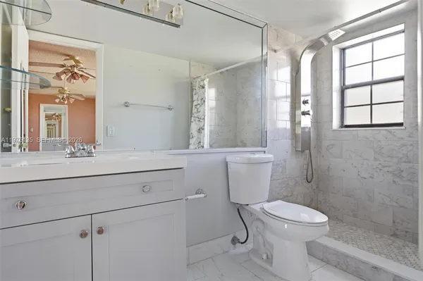 a bathroom with a sink a toilet a mirror and a window