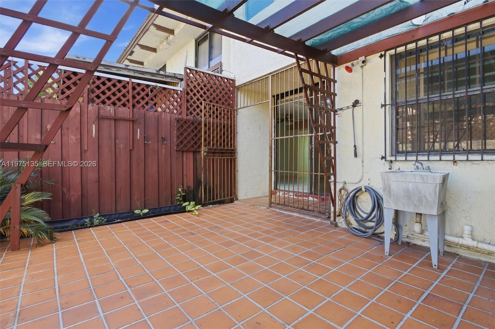 12253 Southwest 16th Terrace, Unit 108M Miami, FL 33175 - Photo 35 of 50 front of a house with a bench and a yard chair