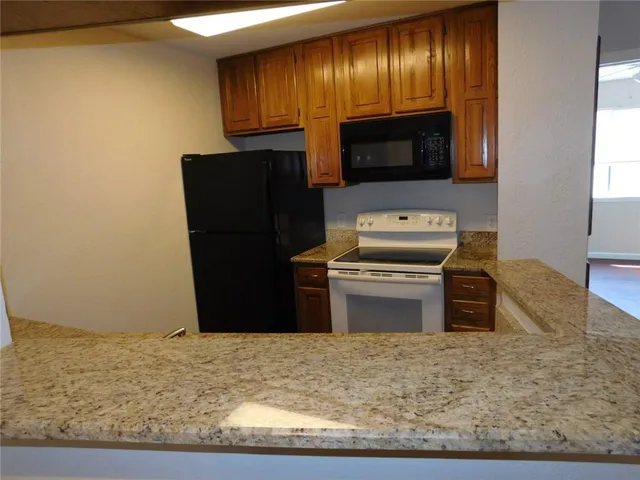 a kitchen with granite countertop wooden cabinets and stainless steel appliances