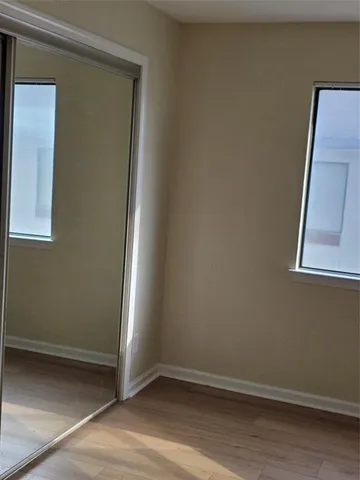 an empty room with wooden floor and mirror