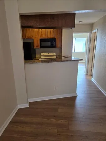 a living room with wooden floor and a flat screen tv
