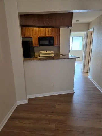 a living room with wooden floor and a flat screen tv