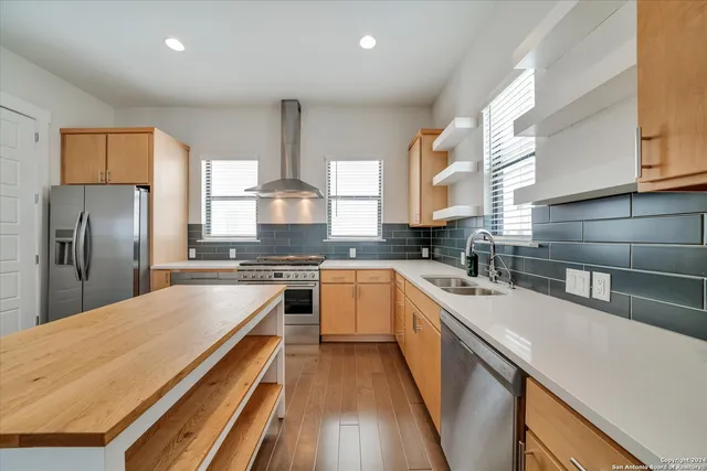 a kitchen with stainless steel appliances granite countertop a stove a sink and a refrigerator
