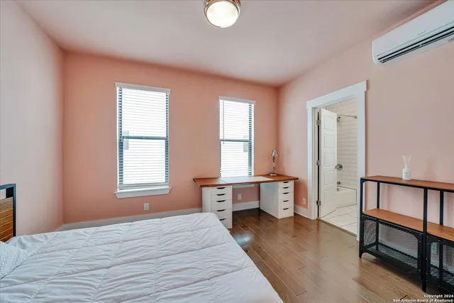 a bedroom with a bed and wooden floor