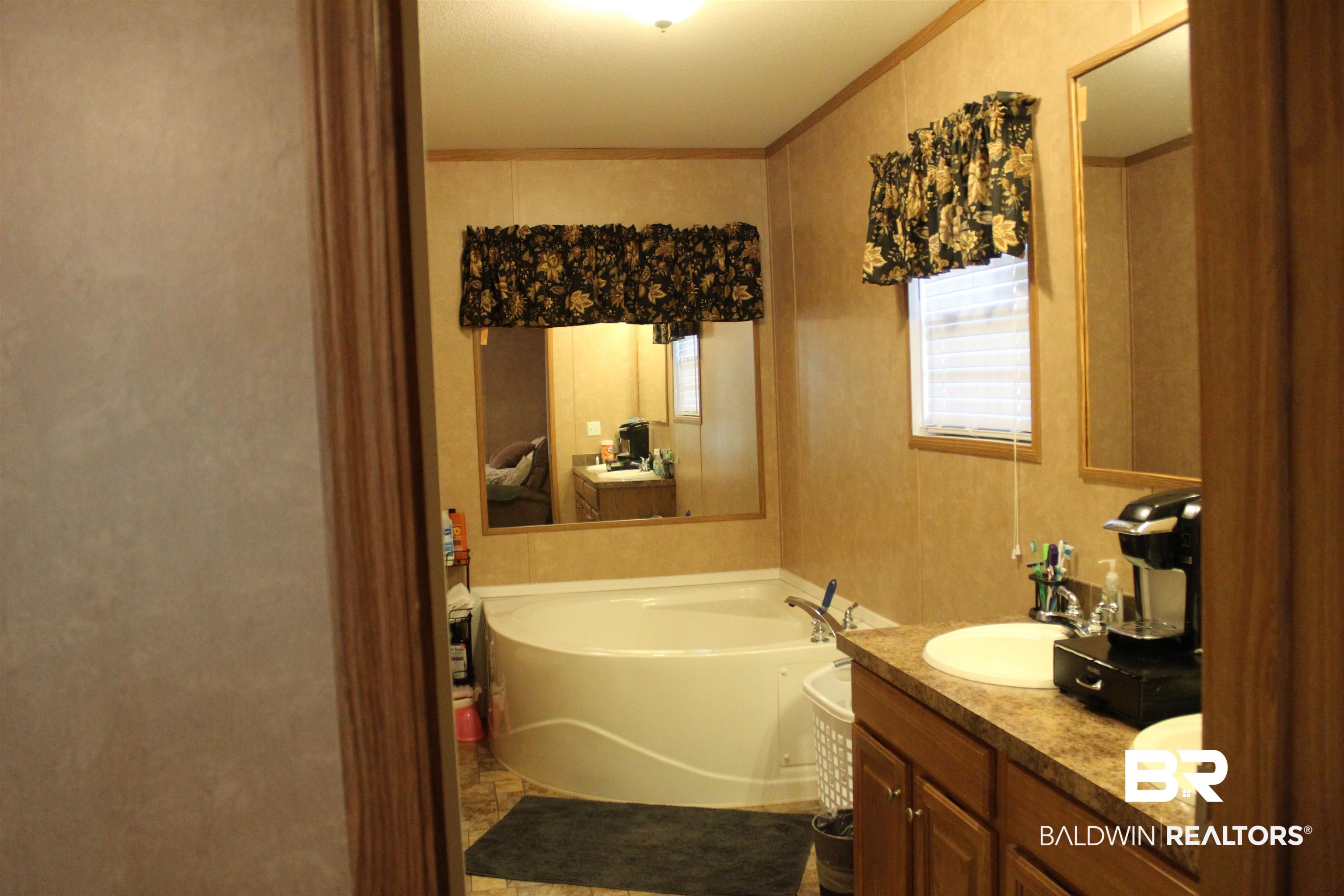 7258 Henderson Road Lowndesboro, AL 36752 - Photo 17 of 22 Full bathroom featuring a garden tub, ornamental molding, and double vanity