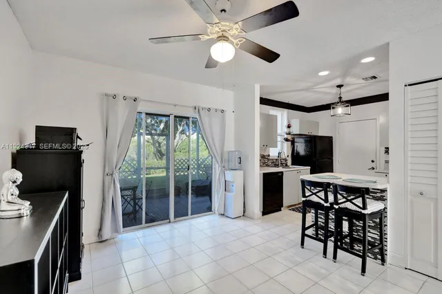 a kitchen with stainless steel appliances granite countertop a stove top oven a sink a dining table and chairs