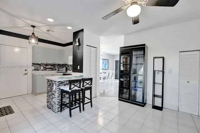 a kitchen with stainless steel appliances kitchen island granite countertop a refrigerator a stove a sink and a dining table