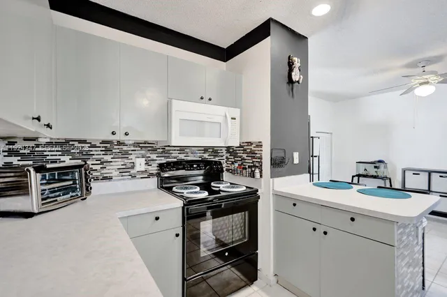 a kitchen with granite countertop a stove sink and cabinets