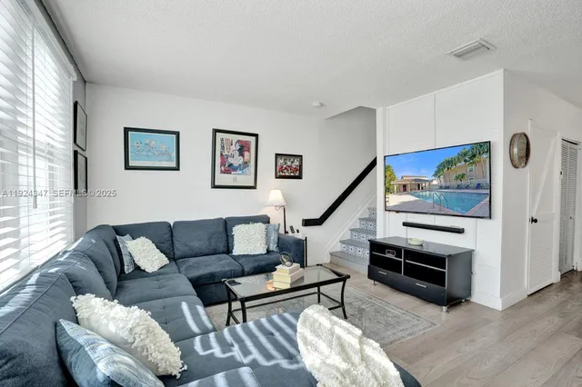 a living room with furniture and a view of kitchen