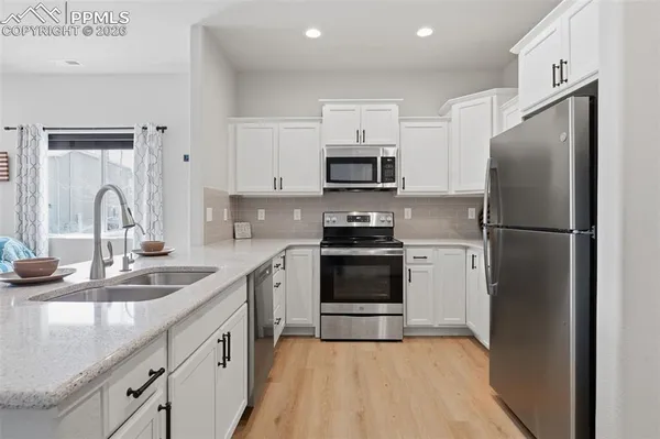 a kitchen with kitchen island a sink appliances and cabinets