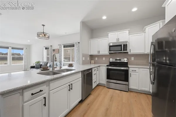 a kitchen with sink a microwave and cabinets
