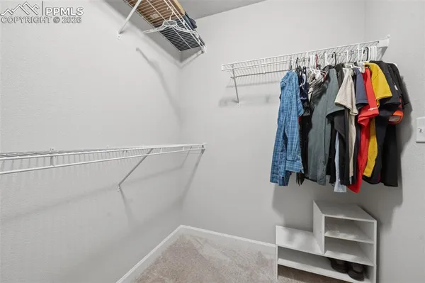 a view of walk in closet with clothes and shoes