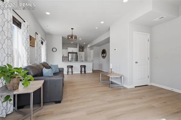 a living room with furniture and a wooden floor