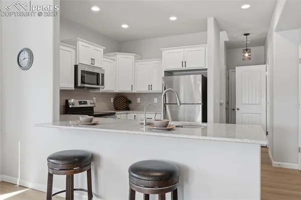a kitchen with stainless steel appliances granite countertop a sink refrigerator and microwave