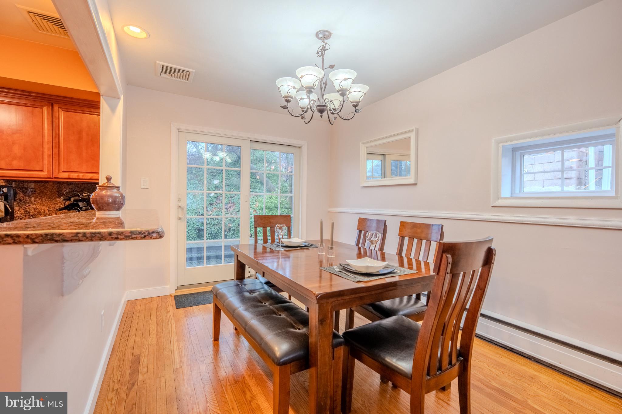 613 Seville Street Philadelphia, PA 19128 - Photo 12 of 37 a dining room with wooden floor a chandelier a wooden table and chairs