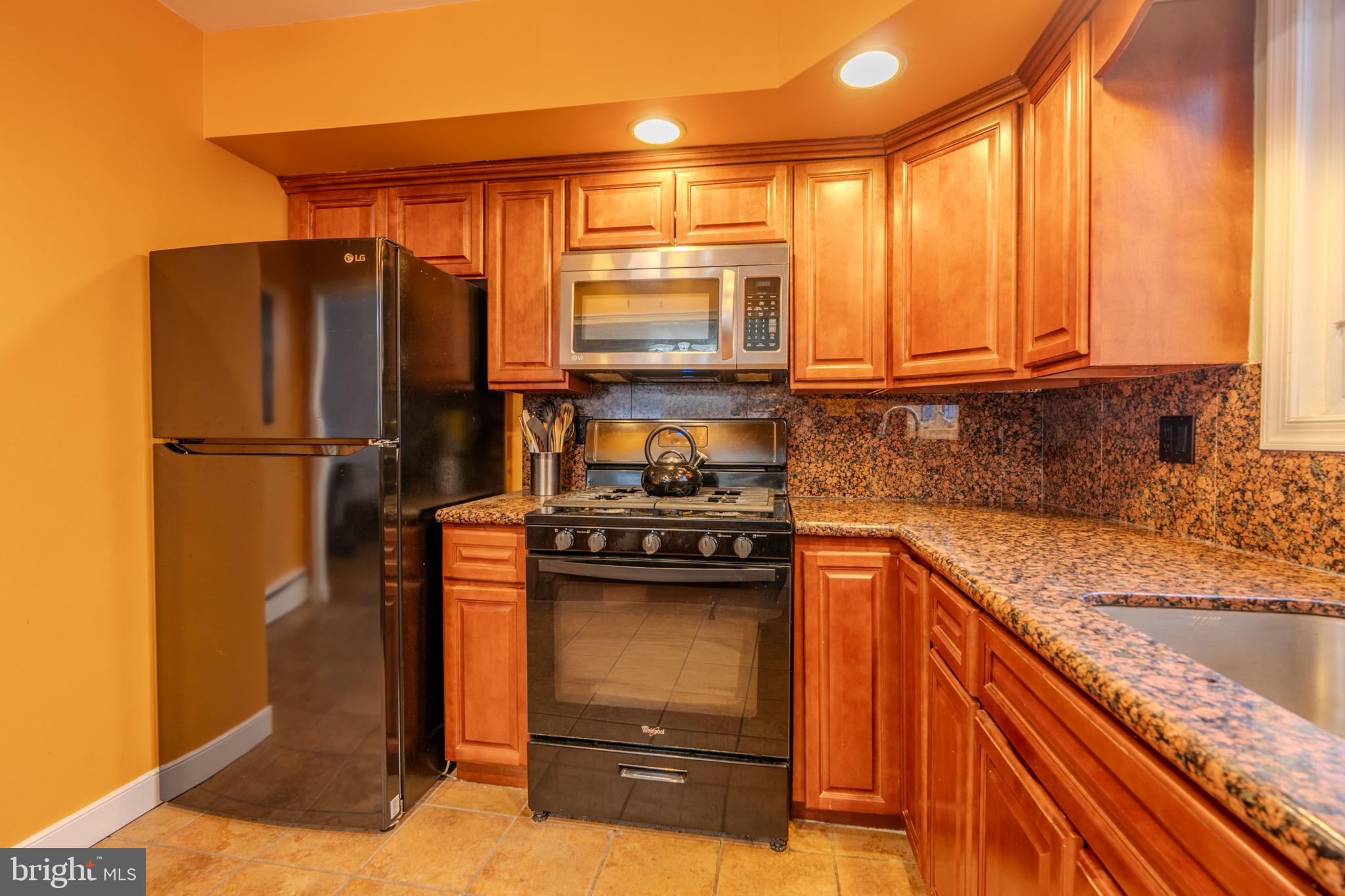 613 Seville Street Philadelphia, PA 19128 - Photo 14 of 37 a kitchen with stainless steel appliances granite countertop a refrigerator stove and sink