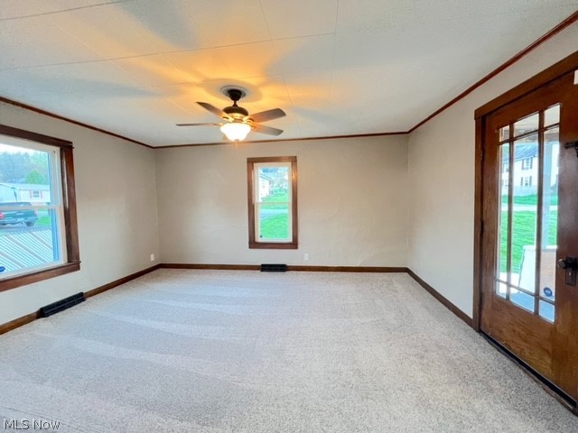 1918 Wainwright Road New Philadelphia, OH 44663 - Photo 3 of 24 Carpeted spare room featuring a healthy amount of sunlight, ceiling fan, and crown molding