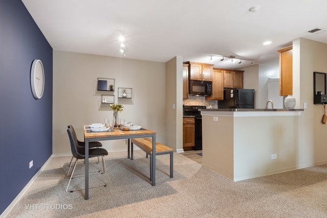 20 Sterling Circle, Unit 103 Wheaton, IL 60189 - Photo 19 of 36 a view of a dining room with furniture and a kitchen