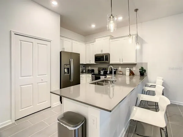 a kitchen with white cabinets and stainless steel appliances