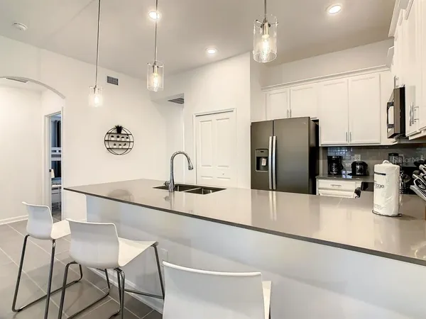 a kitchen with stainless steel appliances granite countertop a refrigerator a sink a stove a microwave and wooden cabinets