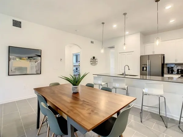 a kitchen with kitchen island a table and chairs in it