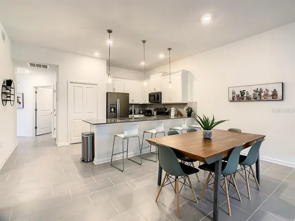 a view of kitchen with refrigerator dining table and chairs