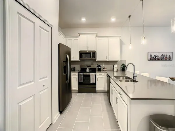 a kitchen with stainless steel appliances granite countertop a refrigerator and a sink