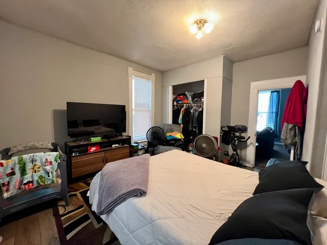 a bedroom with a bed and wooden floor