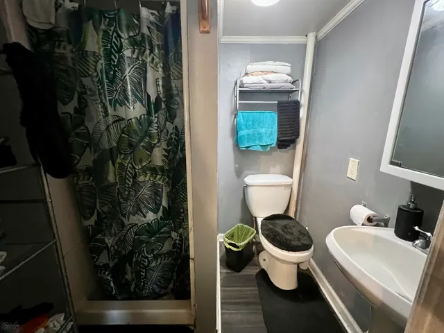 a bedroom with a bed rug and wooden floor