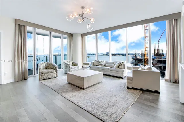 a living room with furniture and a large window with balcony view