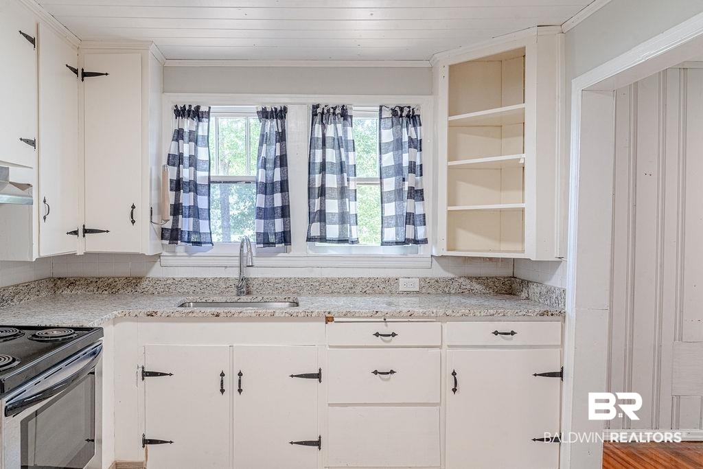 308 East Azalea Avenue Foley, AL 36535 - Photo 6 of 17 Kitchen featuring stainless steel range with electric cooktop, white cabinetry, ornamental molding, light stone counters, and wooden ceiling