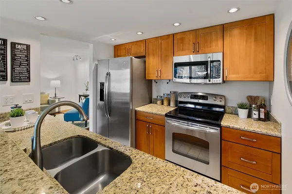 a kitchen with stainless steel appliances granite countertop a sink stove and refrigerator
