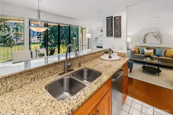a kitchen with granite countertop a sink and a wooden floor