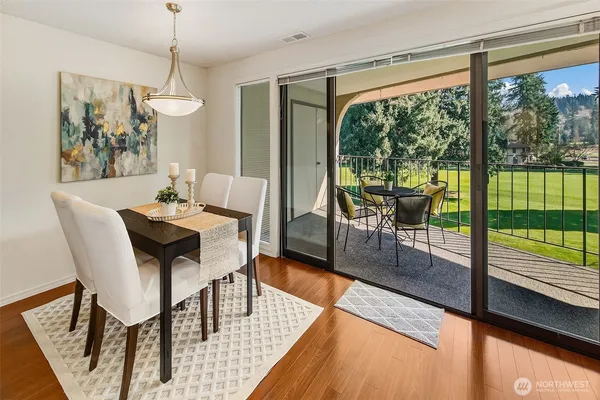 a dining room with furniture a chandelier and wooden floor