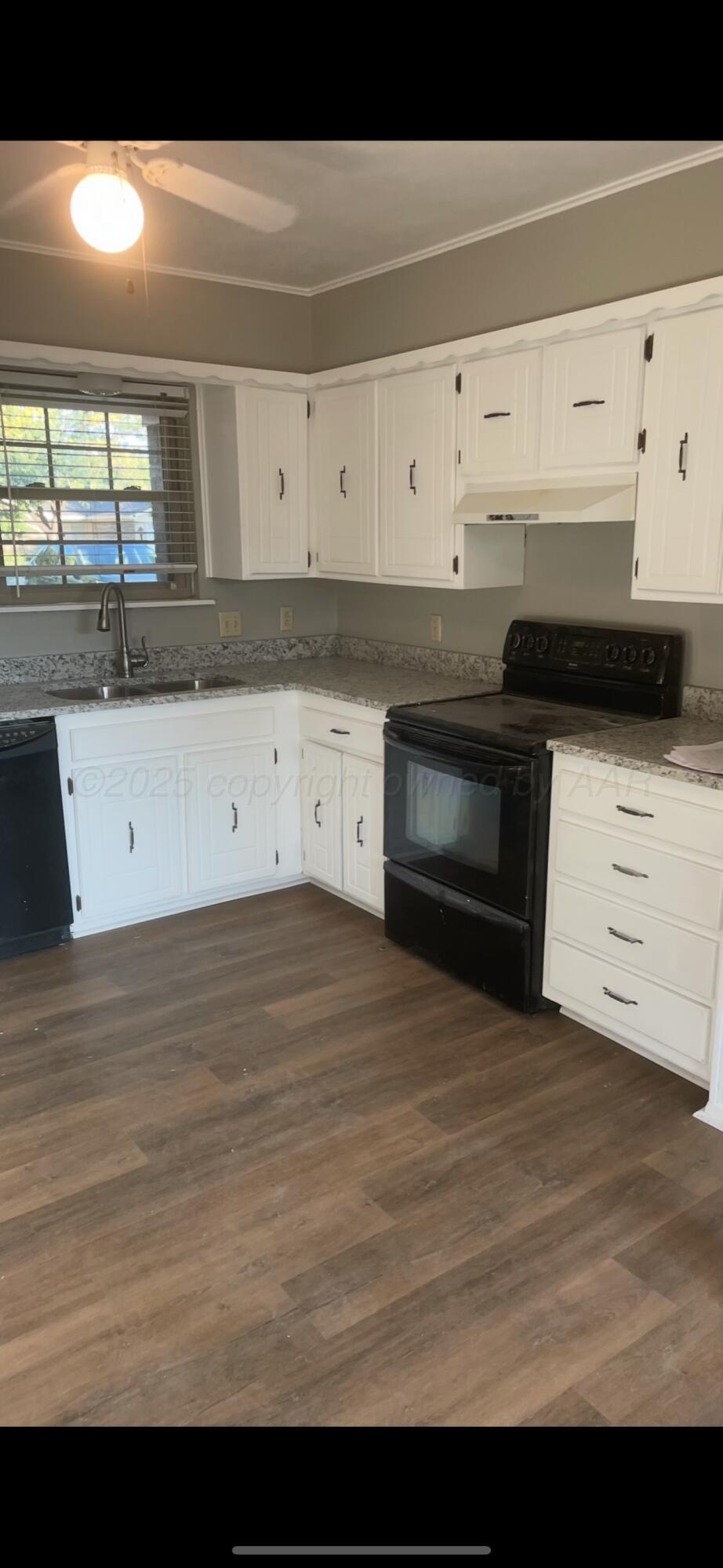 4825 South Austin Street Amarillo, TX 79110 - Photo 5 of 12 a kitchen with a stove and white cabinets