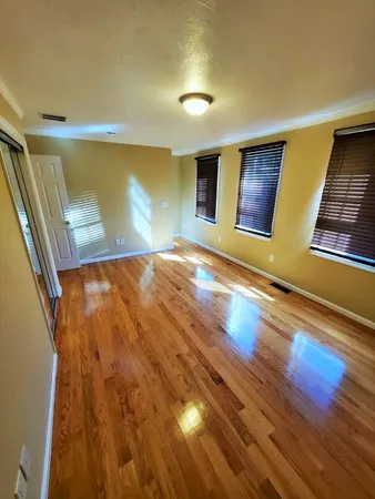 a view of empty room with wooden floor