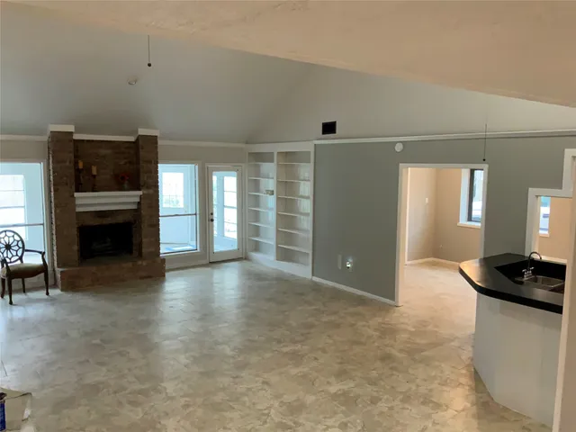 a view of a livingroom with furniture and an empty kitchen