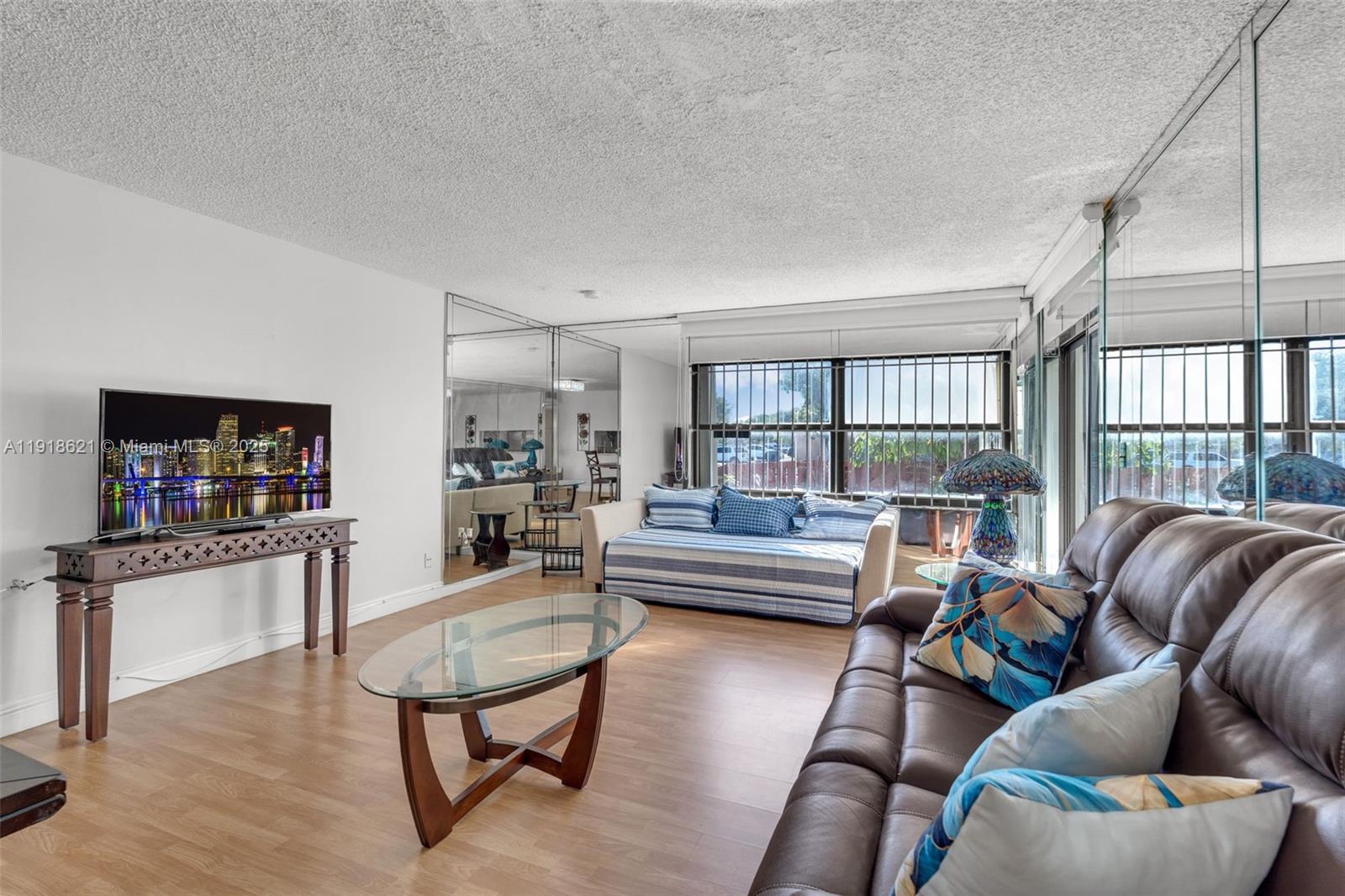 401 Northwest 107th Avenue, Unit 107 Miami, FL 33172 - Photo 11 of 31 a living room with furniture a flat screen tv and a floor to ceiling window