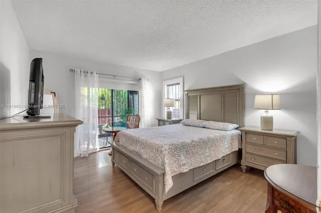 a bedroom with a bed a mirror on dresser and a window