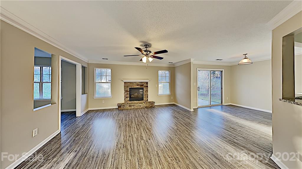 825 Raindrops Road Gastonia, NC 28054 - Photo 5 of 23 an empty room with wooden floor fireplace and windows