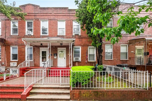 front view of a brick house with a small plants