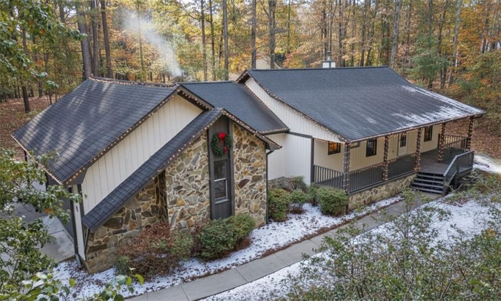 a view of a house with a yard plants and large tree