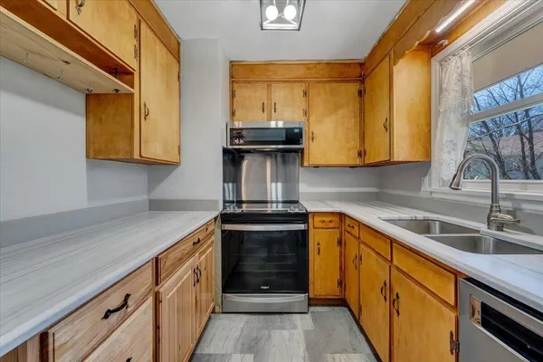 a kitchen with granite countertop cabinets stainless steel appliances a sink and wooden floor