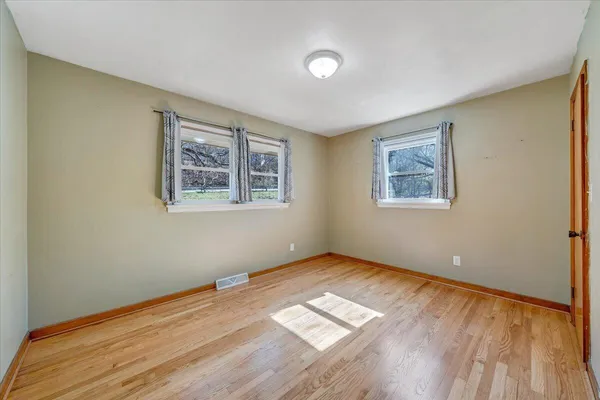 a view of a room with wooden floor and window