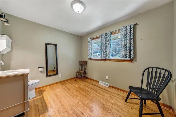 a bedroom with a chair and wooden floor