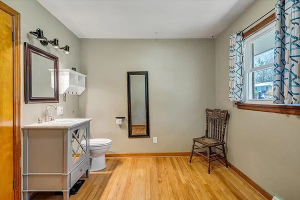 a bathroom with a sink a toilet a mirror and shower